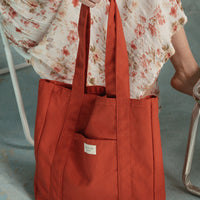 femme tient un sac rouge
