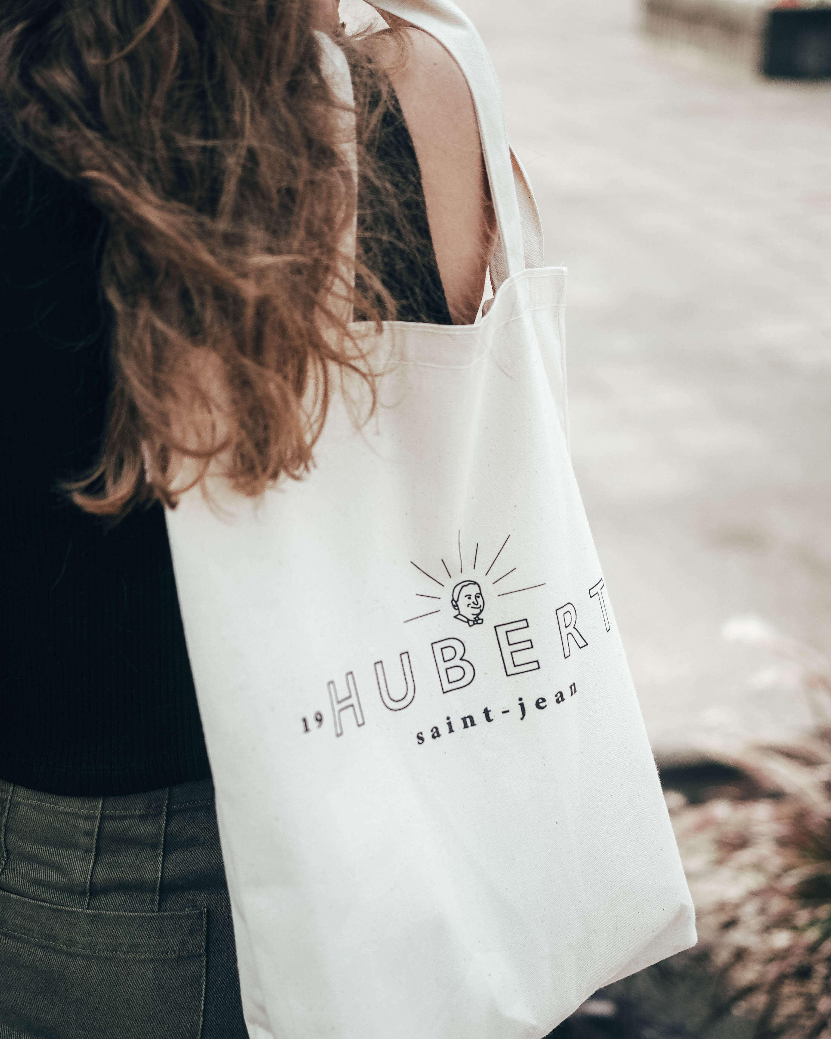 Femme avec un grand sac réutilisable fait sur mesure avec le logo d'une entreprise. Article promotionnel fait au Québec. Woman with a large custom-made reusable bag with a company logo. Promotional item made in Quebec.