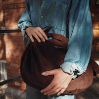 femme tient un sac en corduroy brun