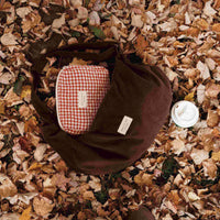 sac corduroy brun sur un sol de feuilles