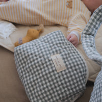 pochette vichy déposé près d'un bébé