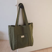 sac kaki sur une poignée de porte