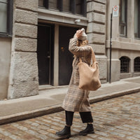 femme qui porte un sac fourre-tout en sherpa beige dans la ville de Montréal