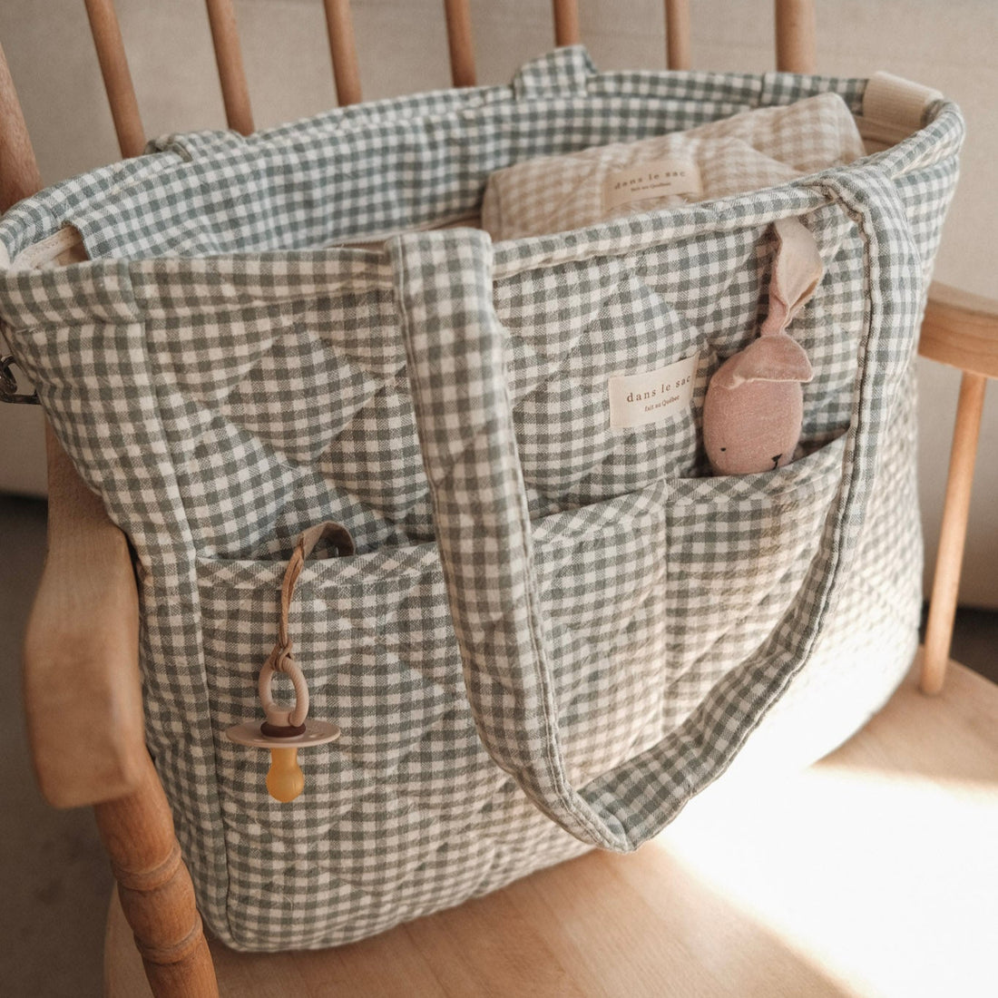 sac à couches vichy sauge sur une chaise berçante