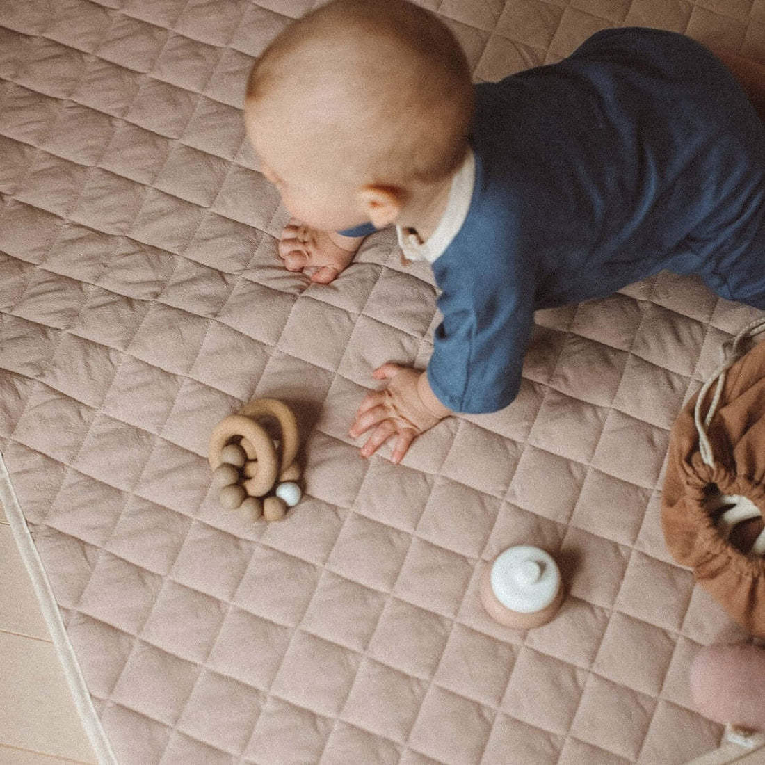 bébé à 4 pattes sur un tapis de jeu neutre