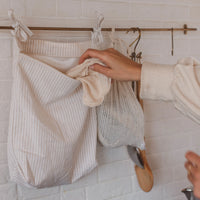 un torchon de tissu est déposé dans un sac imperméable suspendu à une barre murale