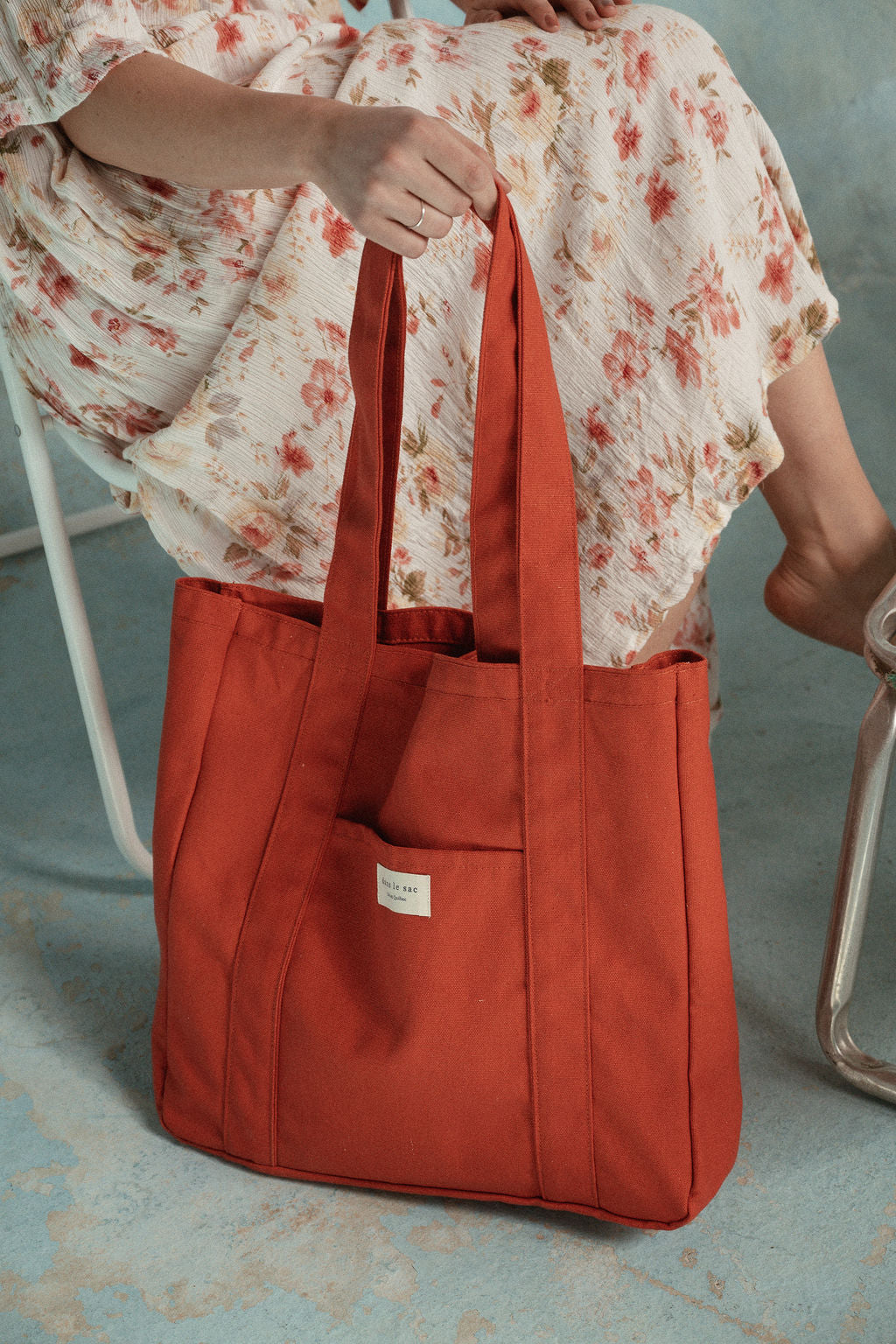 femme tient un sac rouge