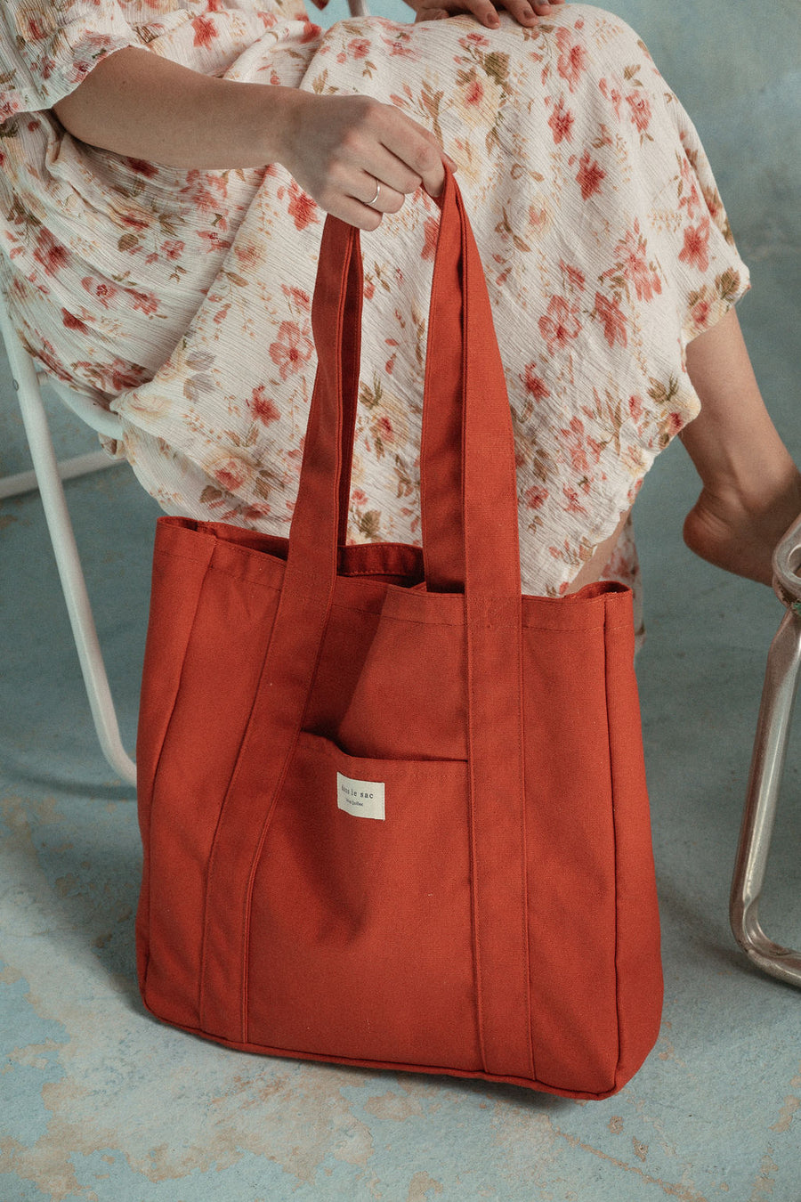 femme tient un sac rouge