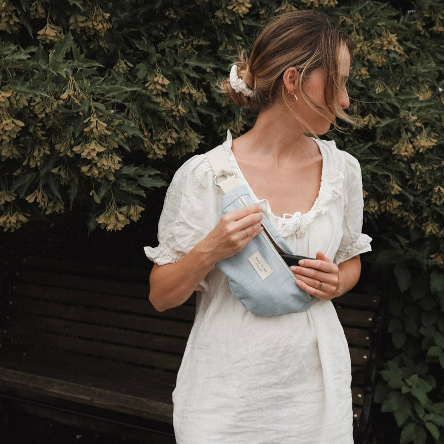 femme porte sac banane en jeans en bandoulière