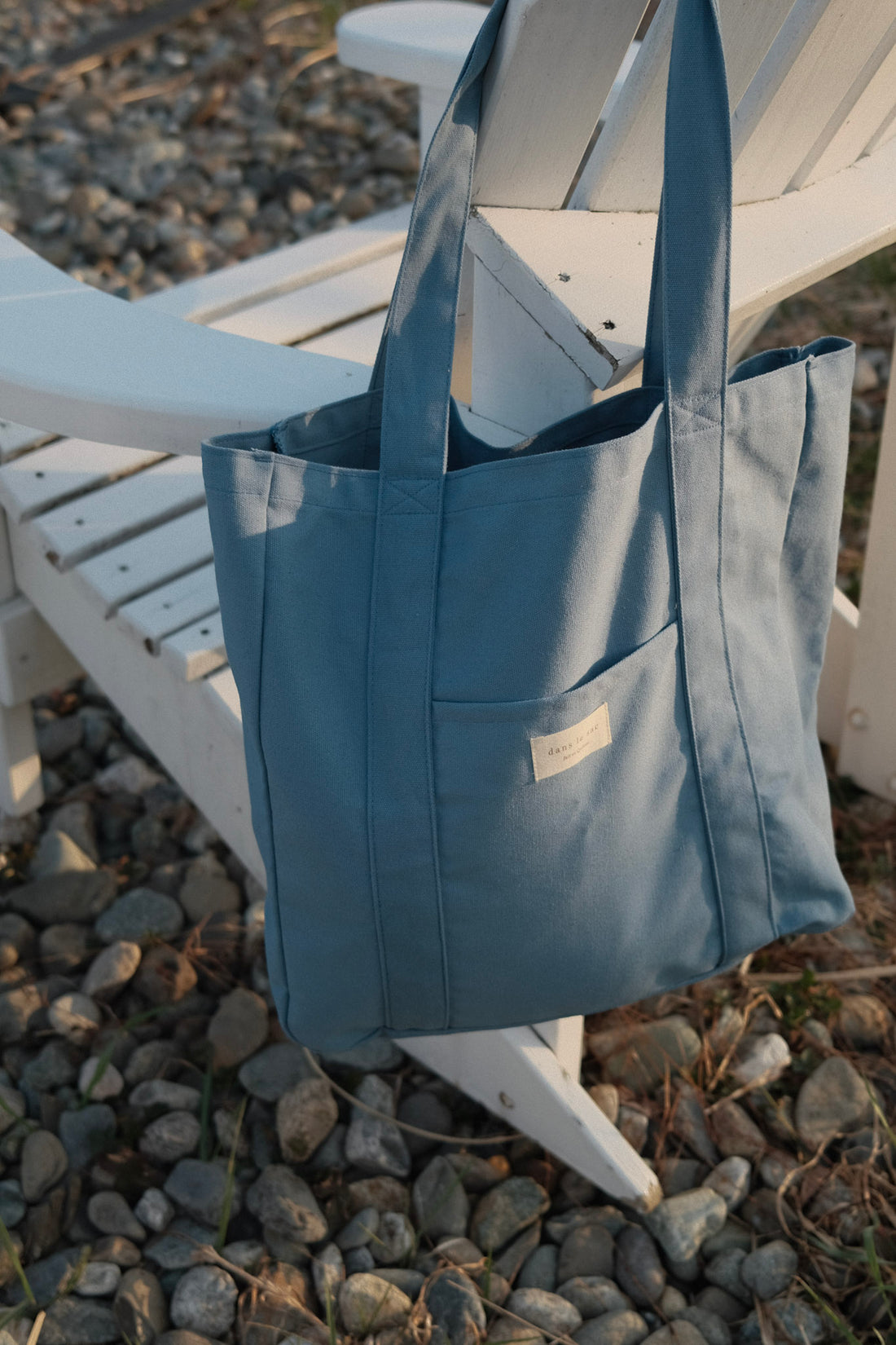 sac bleu sur un dossier de chaise en bois