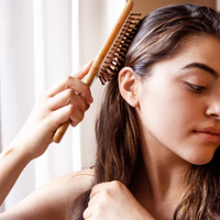 femme se brosse les cheveux