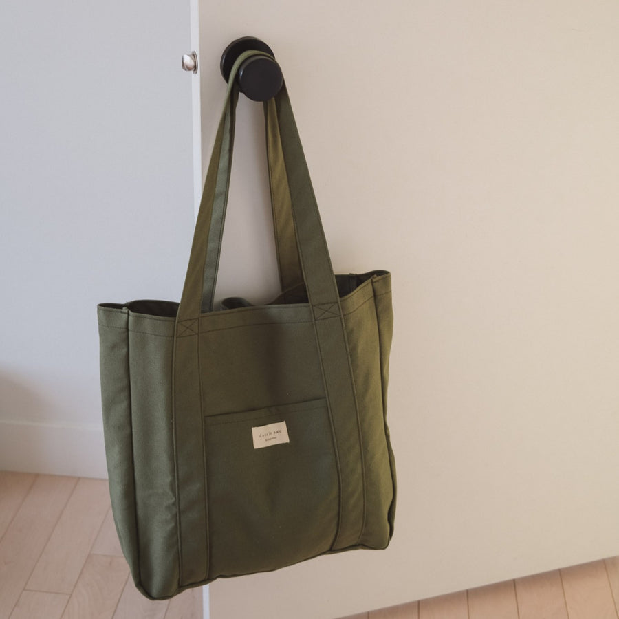 sac kaki sur une poignée de porte