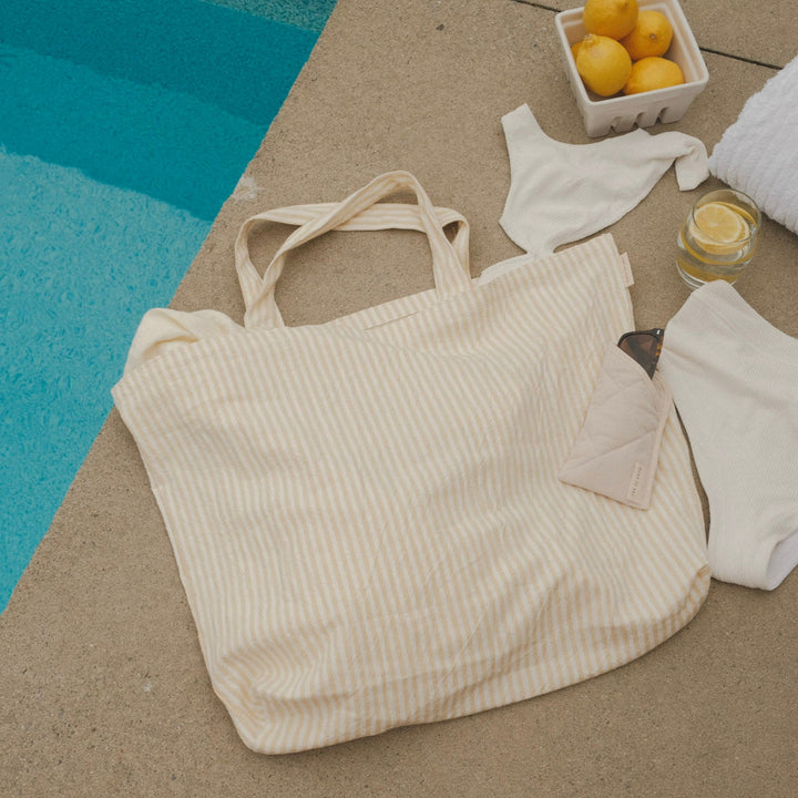 sac rayé jaune au bord d'une piscine