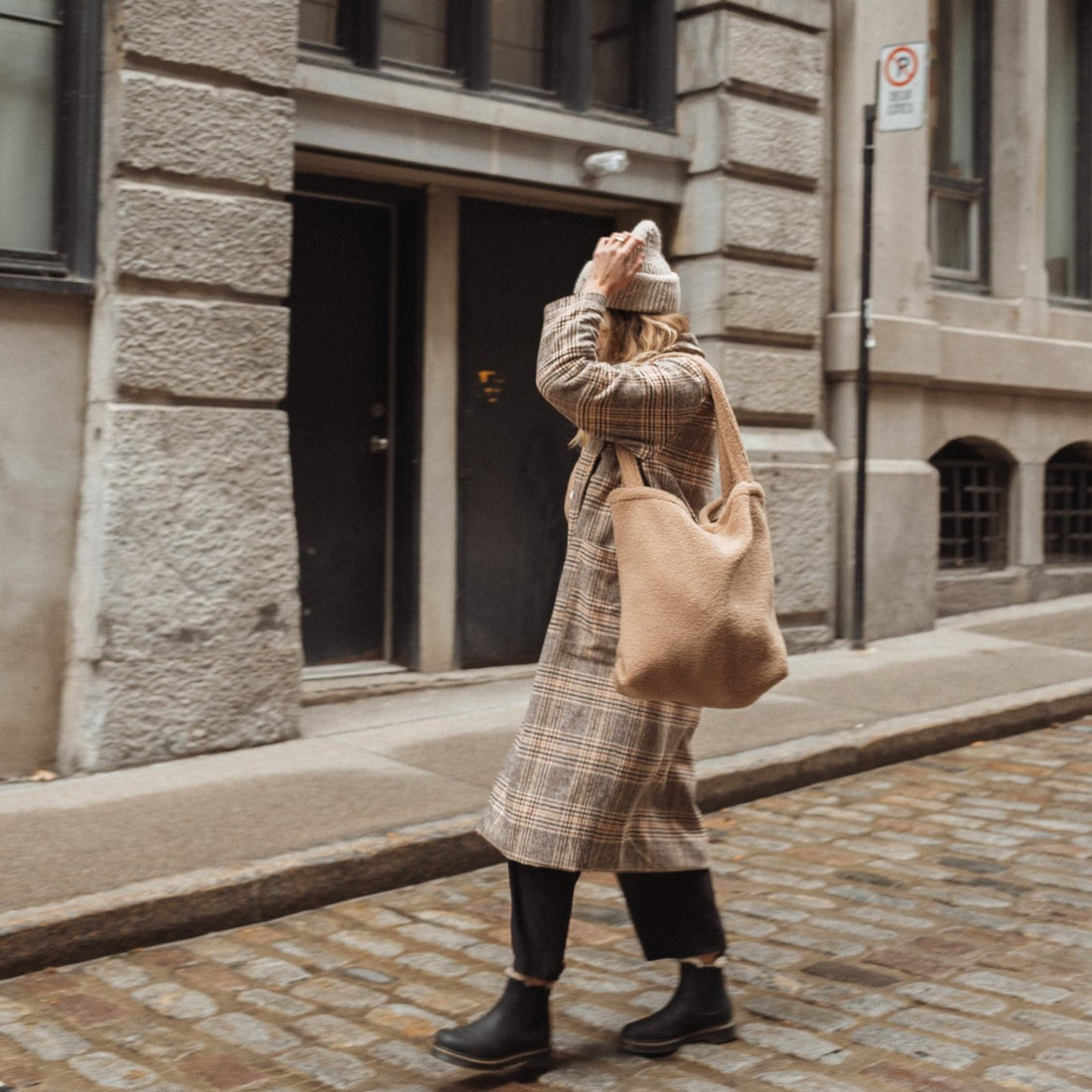 femme qui porte un sac fourre-tout en sherpa  beige dans la ville de Montréal