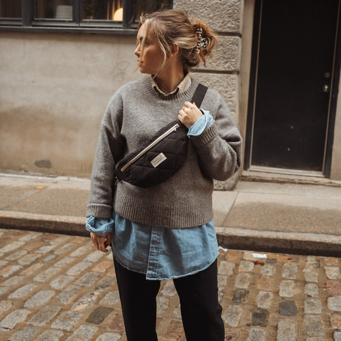 femme qui porte un sac banane noir dans la ville de Montréal