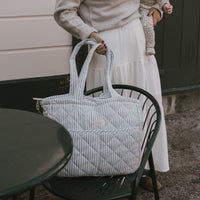 sac à couches rayé bleu sur une chaise extérieure