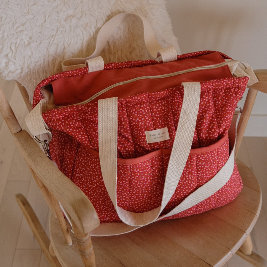 sac à langer rouge sur une chaise