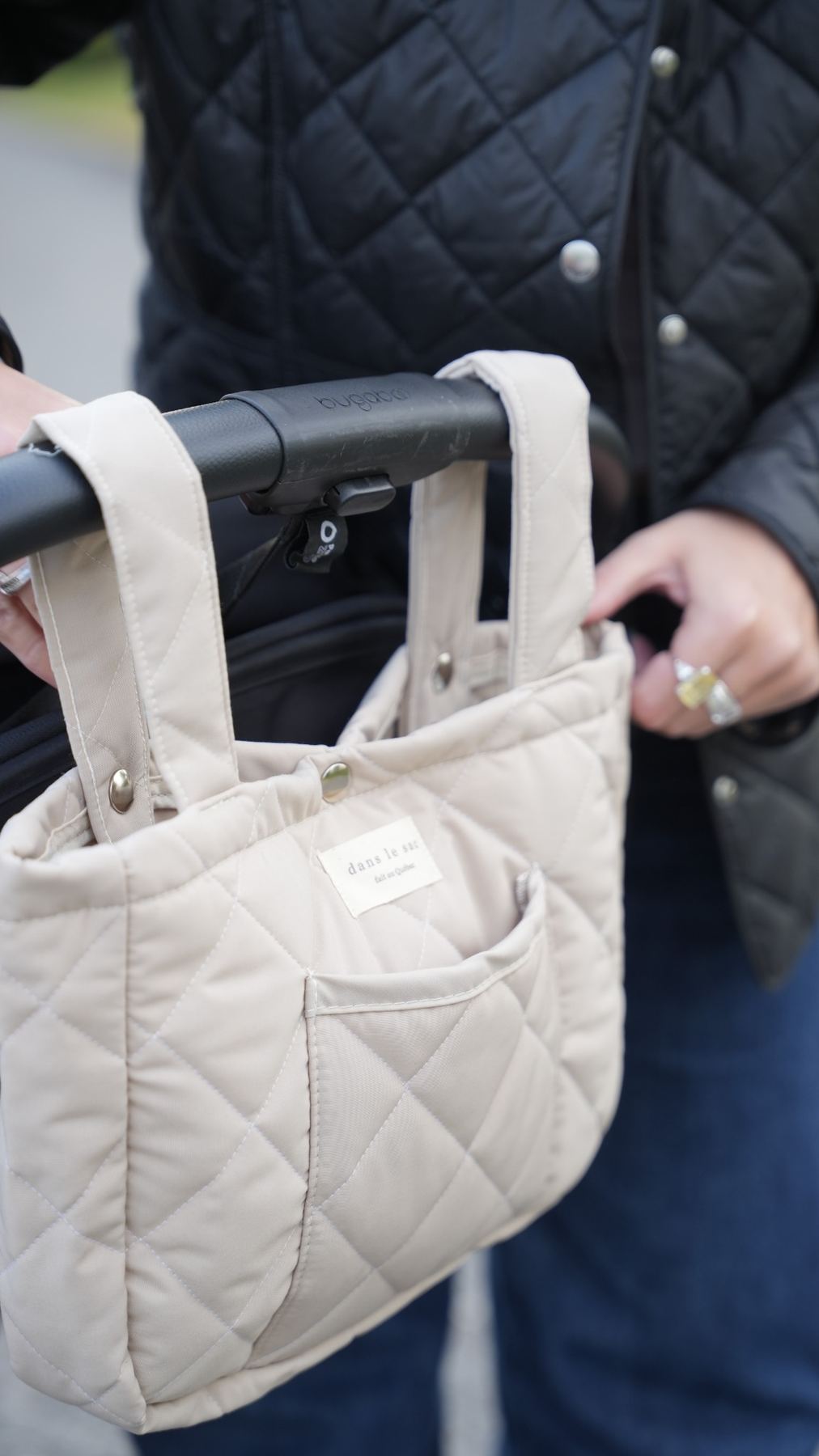 Organisateur de poussette matelassé couleur avoine de Dans le sac, confectionné au Québec avec des tissus Canada Goose récupérés, fixé à une poussette.