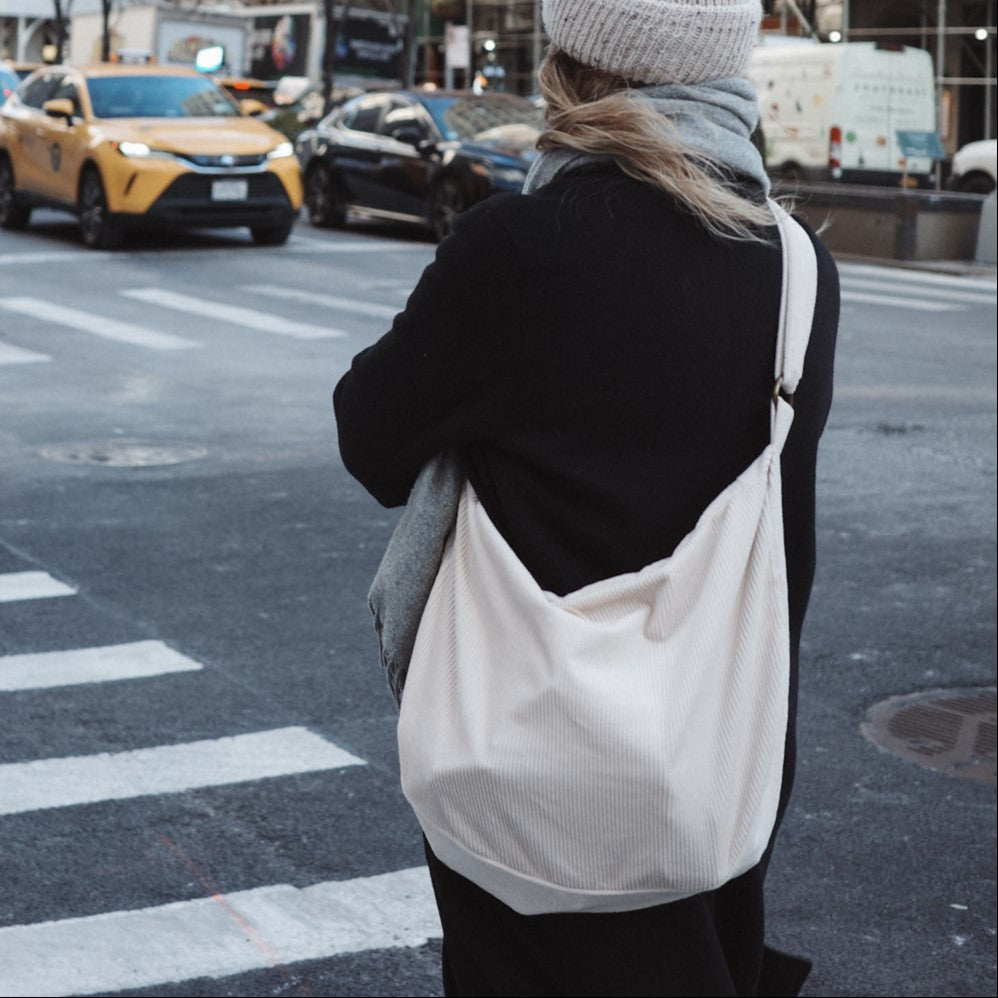 femme porte un sac en corduroy en bandoulière