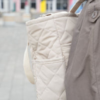 Sac à dos matelassé couleur avoine de Dans le sac, confectionné au Québec à partir de tissus Canada Goose récupérés, avec bretelles ajustables et poches pratiques.