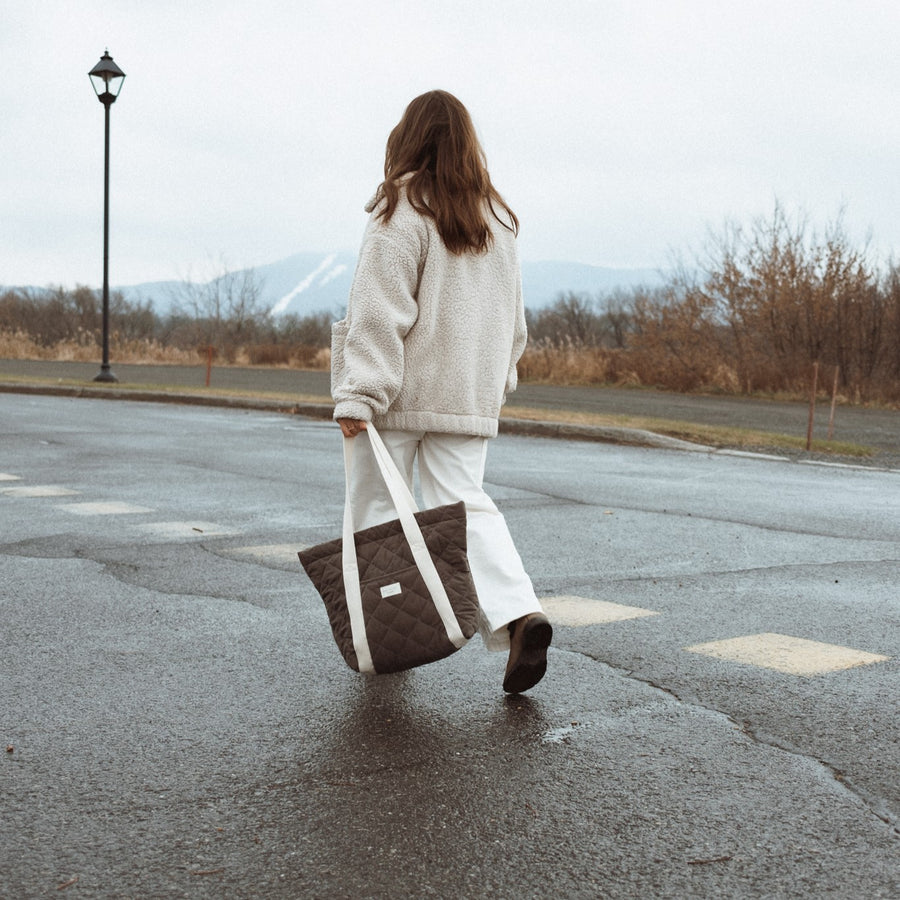 femme marche en tenant un sac