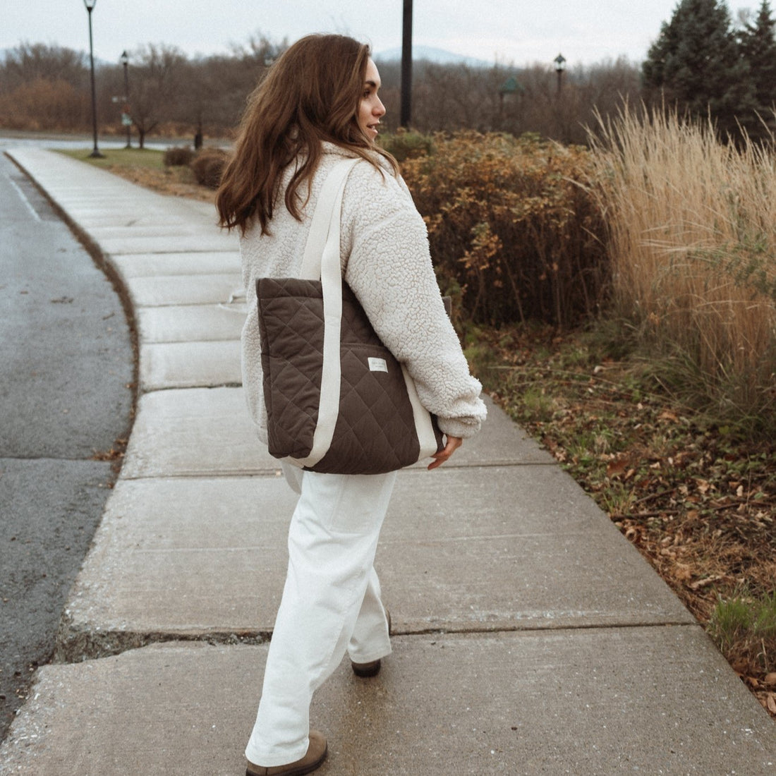 femme marche en tenant un sac kaki vert