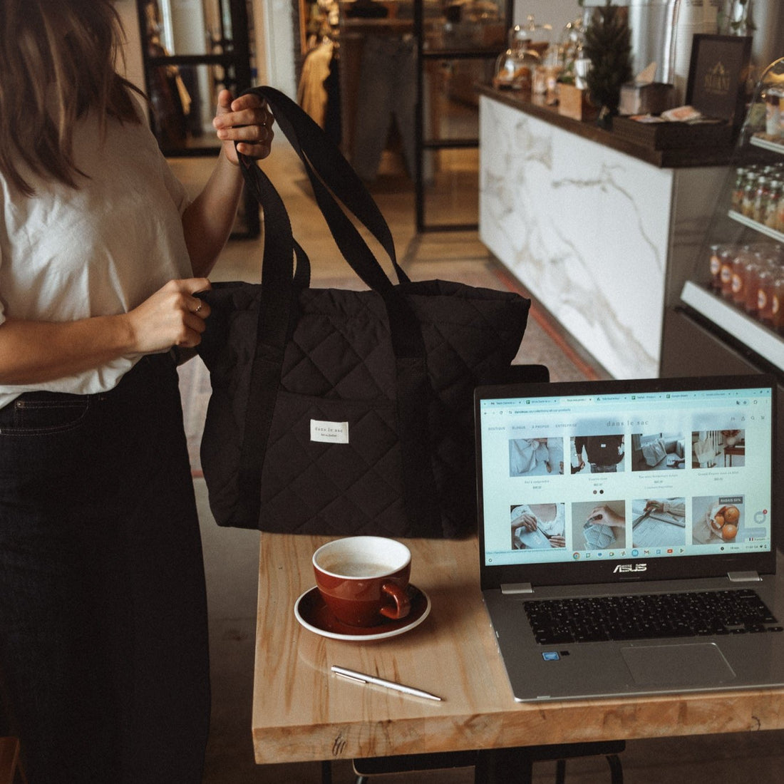 femme dépose sac matelassé noir sur une table