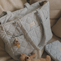 Sac à couches rayé bleu sur un sofa