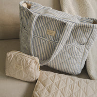 Sac à couches pochette et tapis à langer sur un sofa