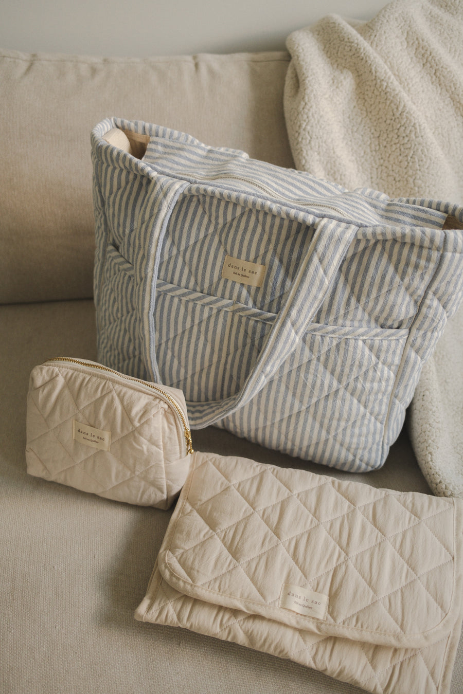 Sac à couches pochette et tapis à langer sur un sofa