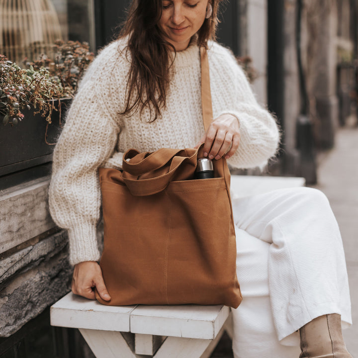 femme portant un sac à bandoulière brun