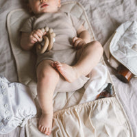 bébé sur un tapis de change en tissu fait au Québec