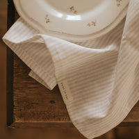 linge à vaisselle rayé avec une assiette antique
